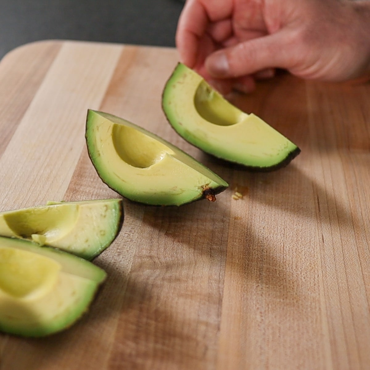 slicing the avocados into four pieces

