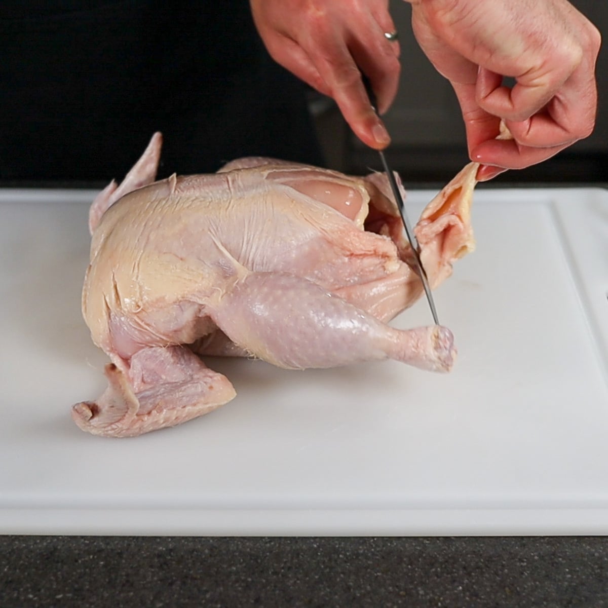 trimming excess fat off a whole chicken