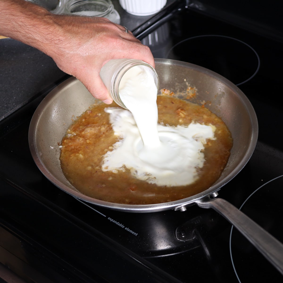 adding heavy cream to the pan