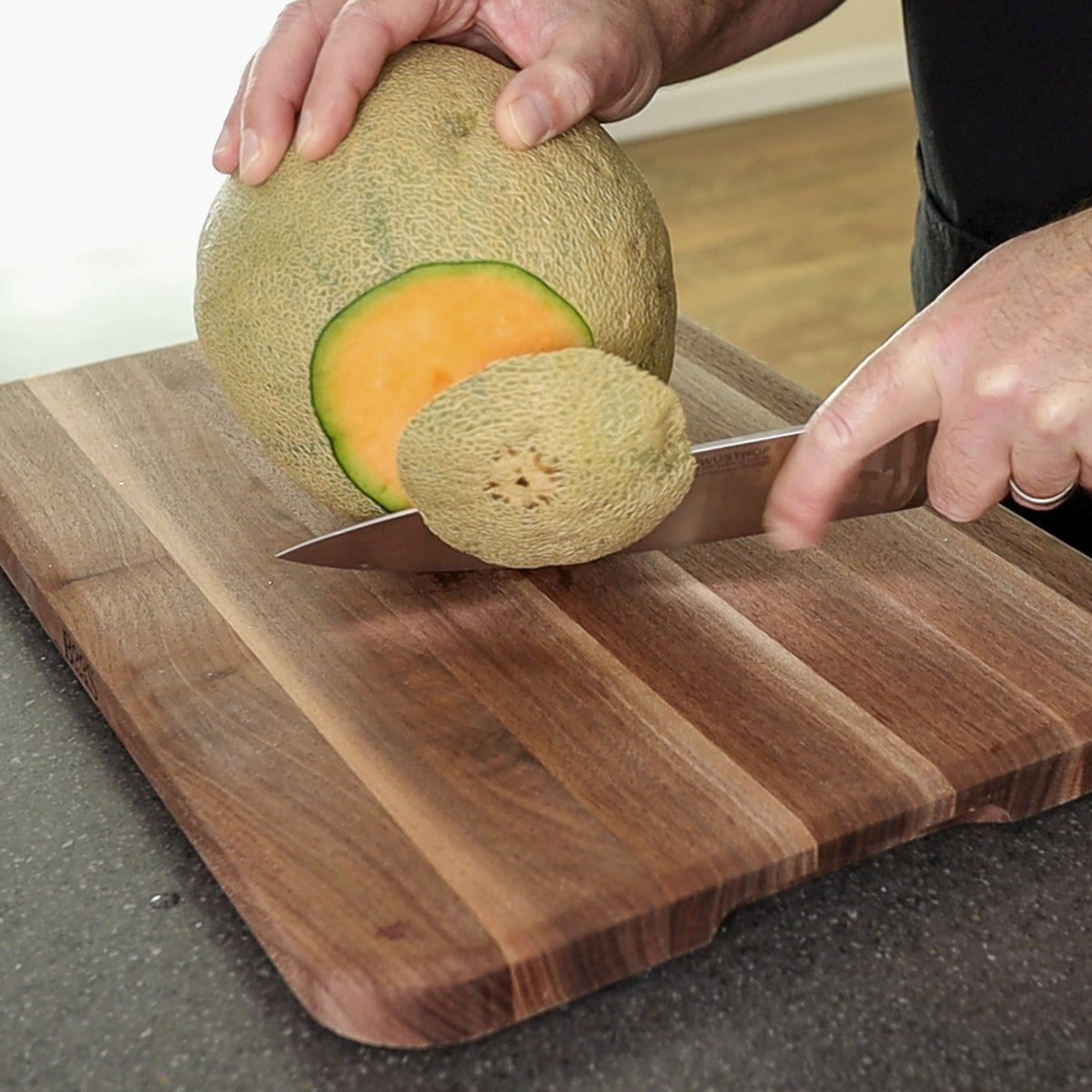 Cutting the end off of the cantaloupe
