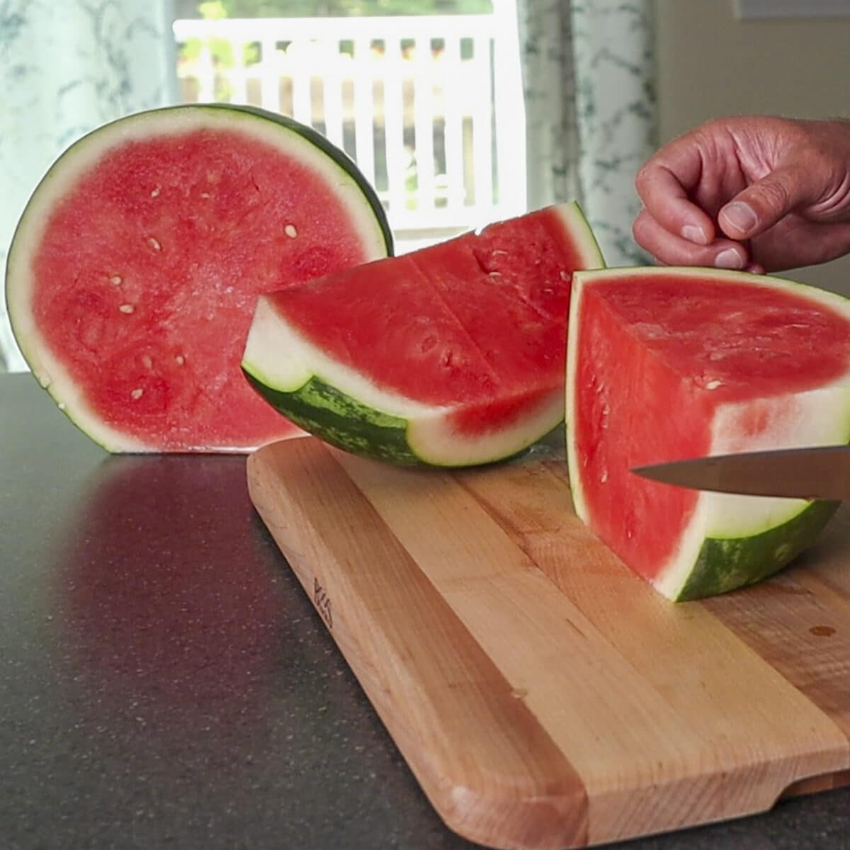 watermelon being cut on a cutting board