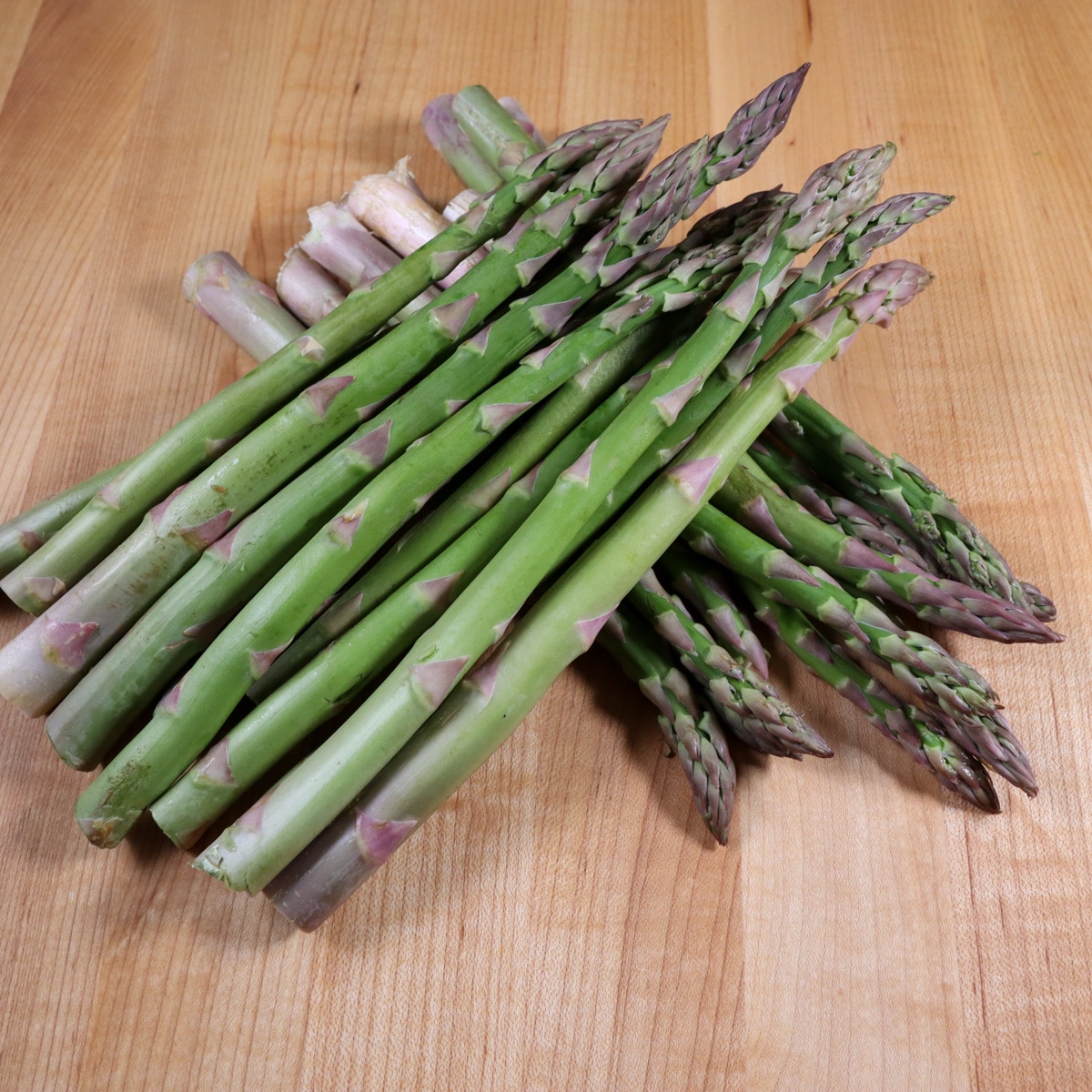 pile of asparagus on a cutting board
