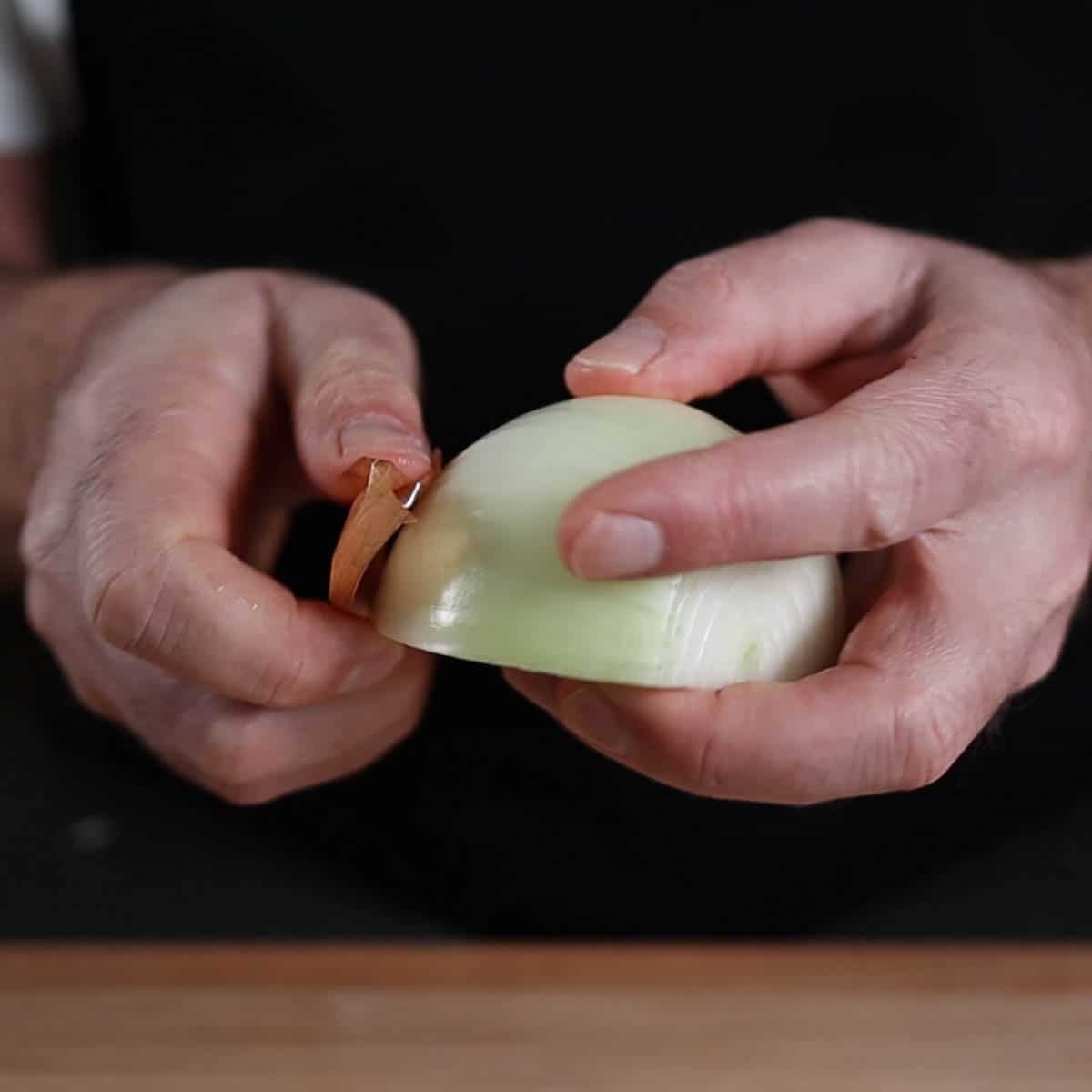 Man hands holding a peeled onion