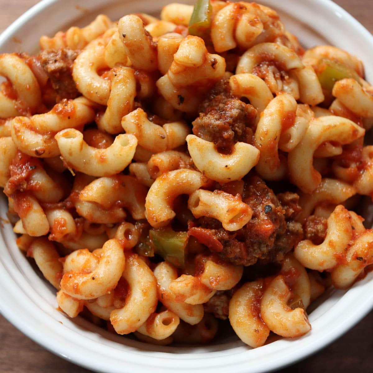 Up close bowl of American chop suey: Macaroni elbows, ground beef, green peppers and tomato sauce.