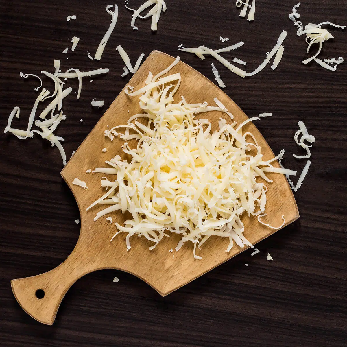 Grated cheese on a cutting board.