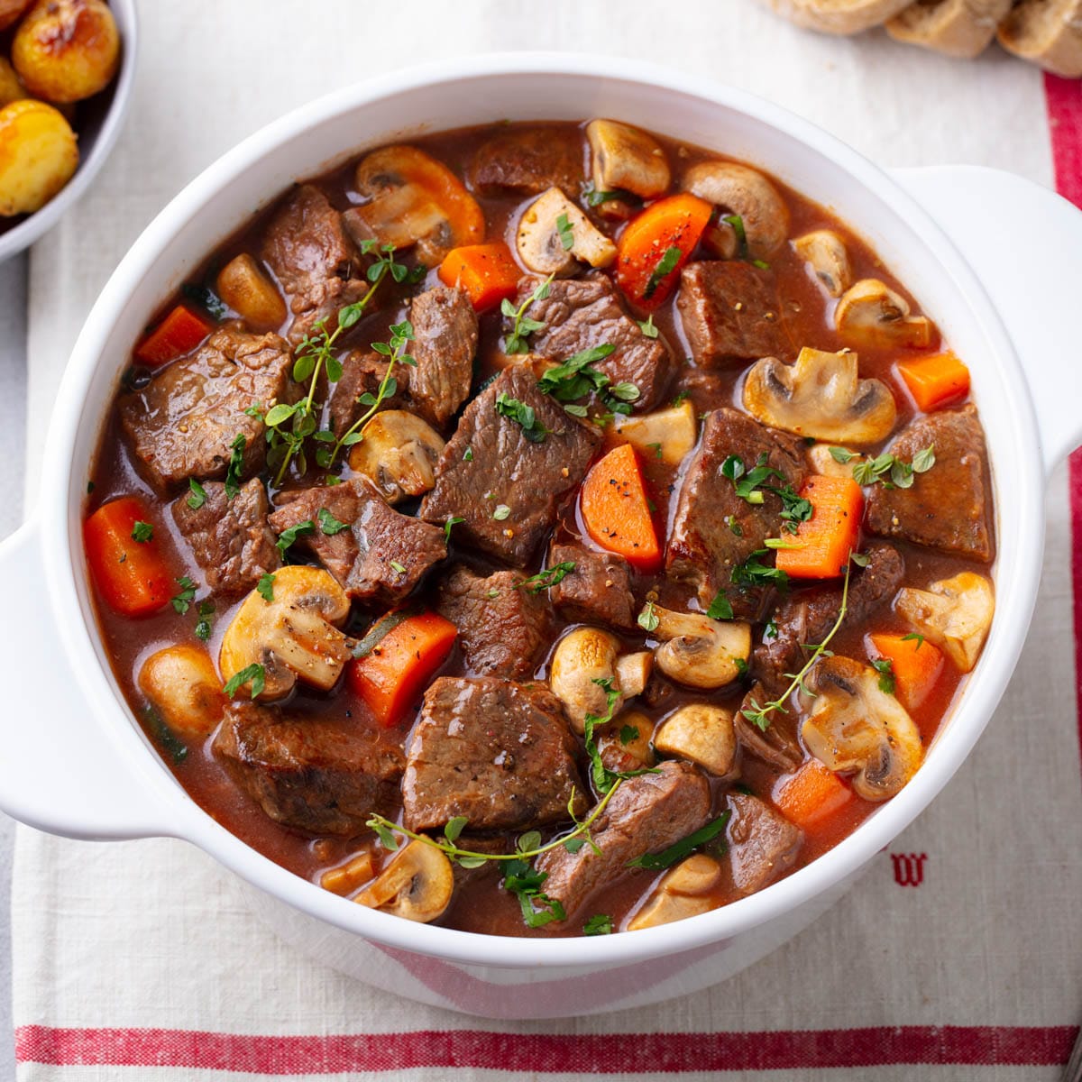 Hearty beef stew in a white bowl.