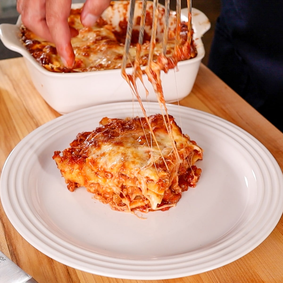 plating a slice of lasagna onto a plate