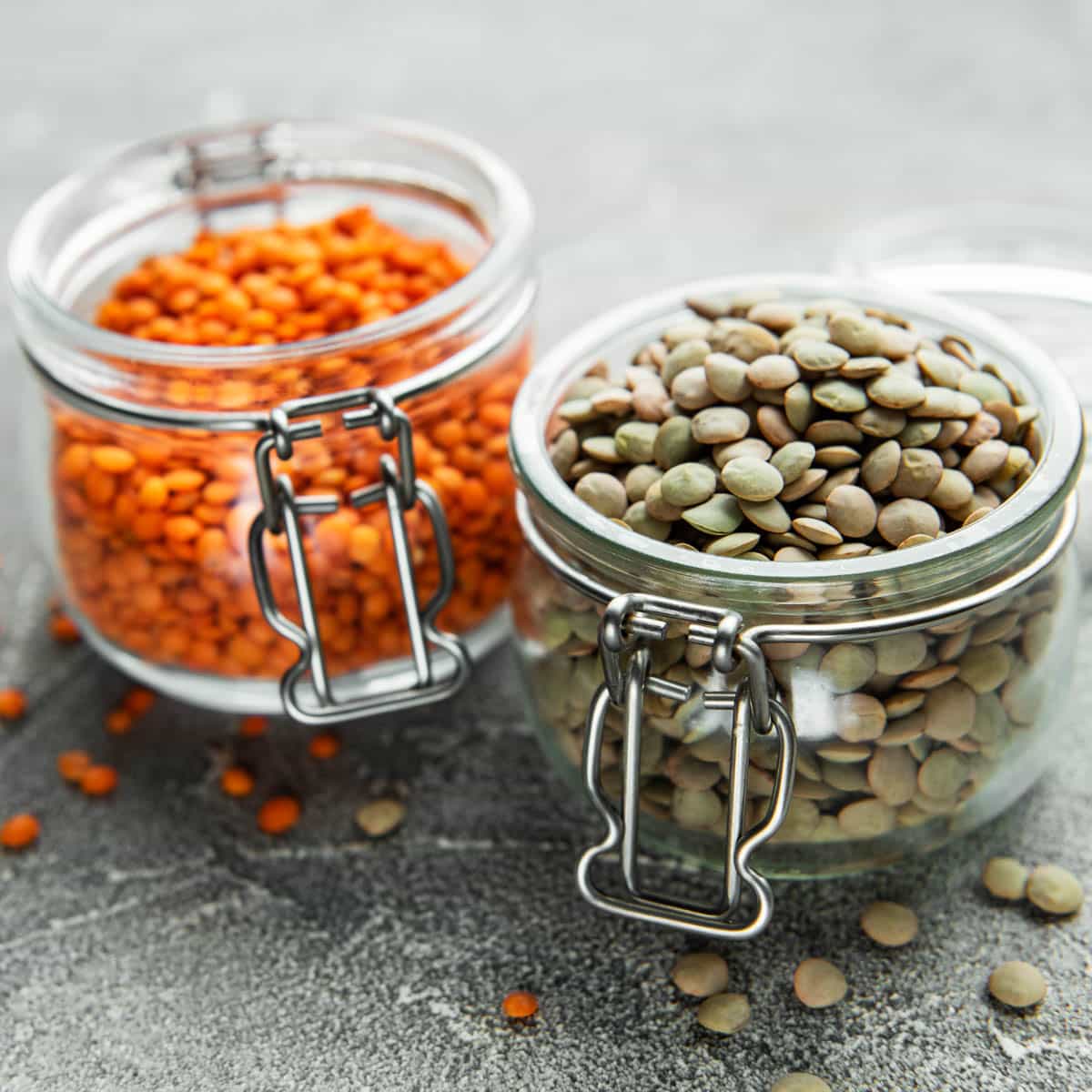 Red and green lentils in glass jars.