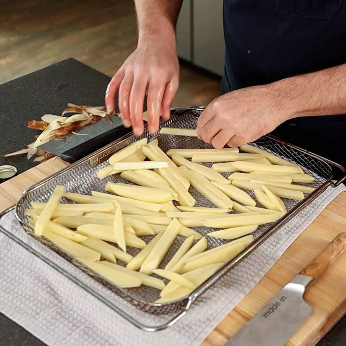 Arranging French fries in an air fryer basket